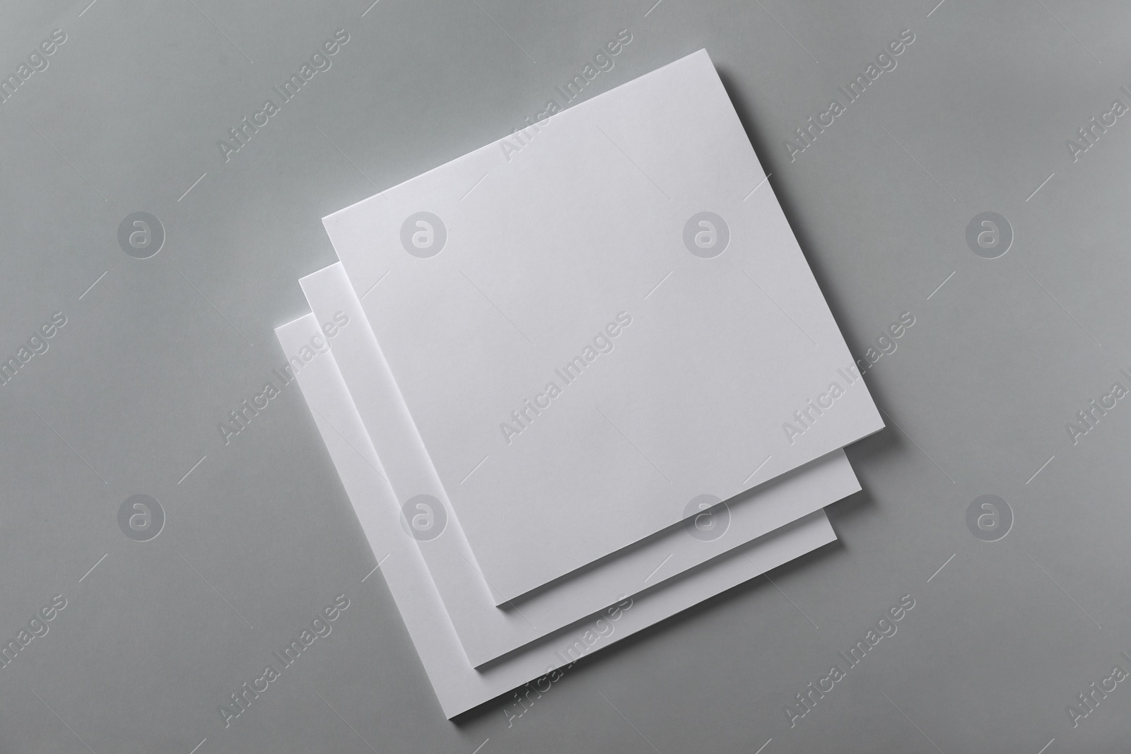 Photo of Stack of blank paper sheets for brochure on light grey background, top view