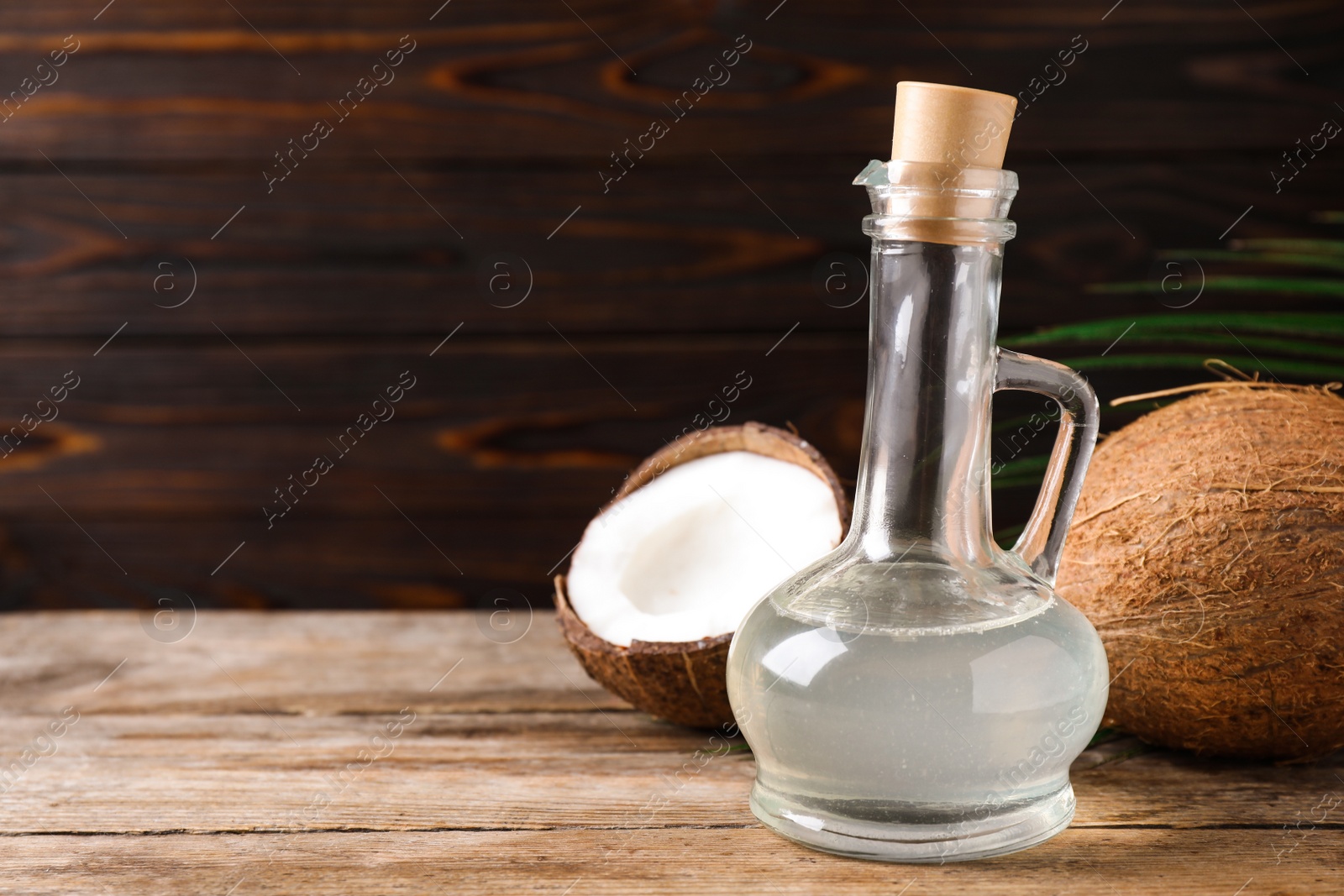 Photo of Coconut oil on wooden table. Space for text