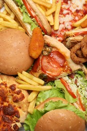 Photo of French fries, pizza and other fast food as background, top view