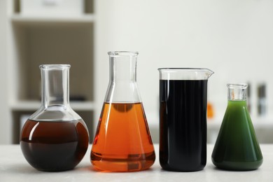 Photo of Flasks and beaker with different types of crude oil on light table