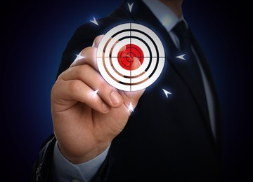 Image of Businessman aiming at virtual screen with digital target against dark blue background, closeup