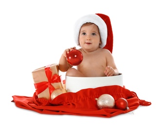 Cute little baby wearing Santa hat sitting in box with Christmas gift on white background