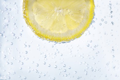 Juicy lemon slice in soda water, closeup