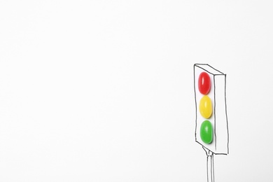 Colorful jelly candies arranged as traffic light on white background, top view