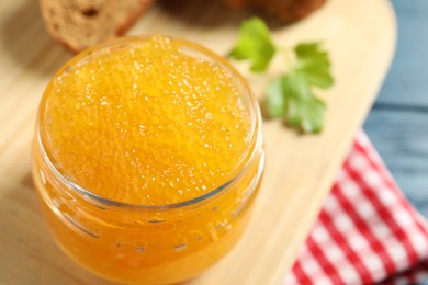 Photo of Fresh pike caviar in glass jar, bread and parsley on blue wooden table, closeup