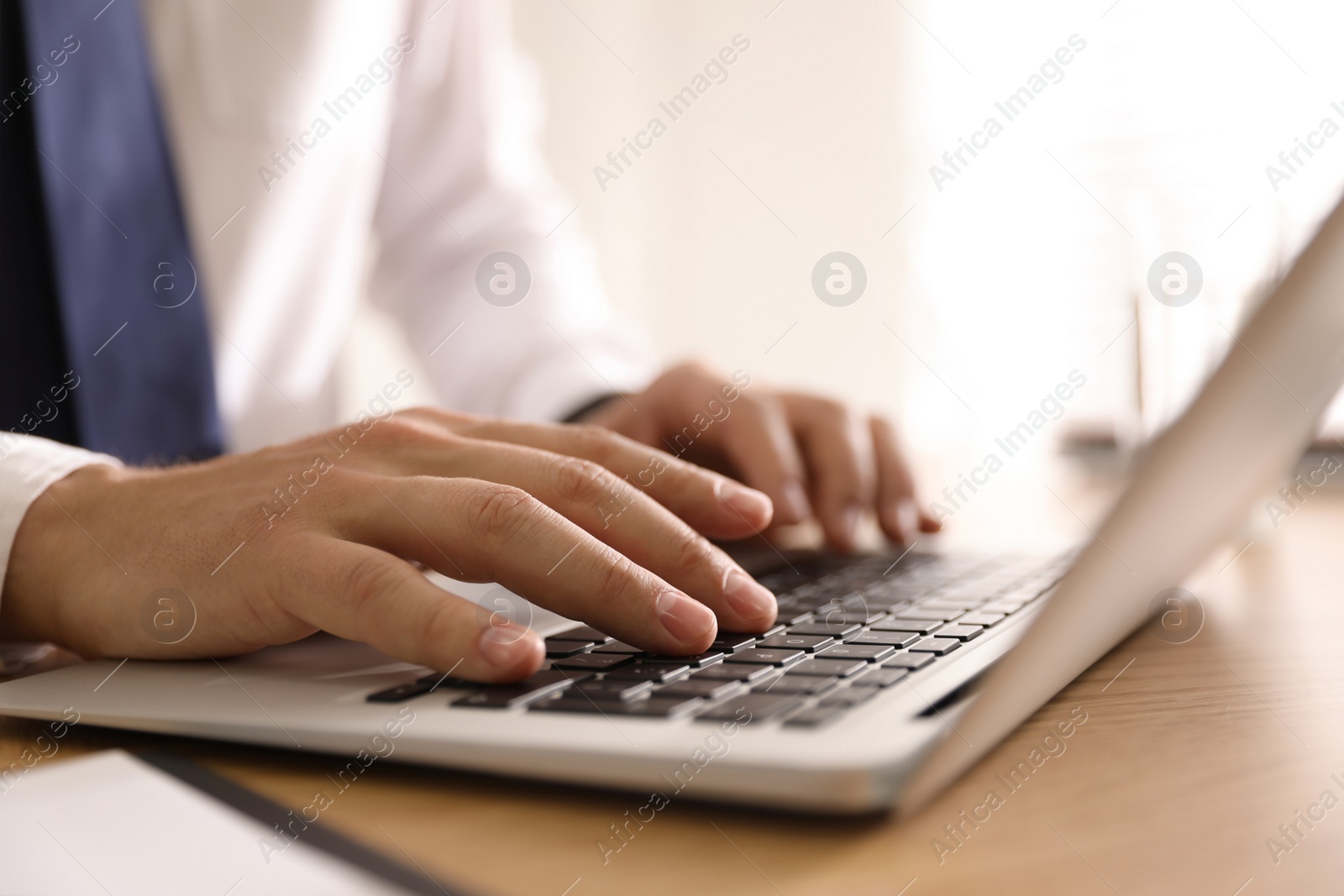 Photo of Man working with laptop in office, closeup of hands