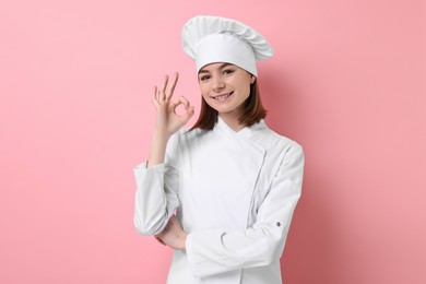 Photo of Professional chef showing OK gesture on pink background