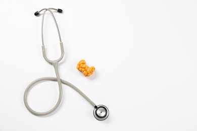 Endocrinology. Stethoscope and model of thyroid gland on white background, top view. Space for text