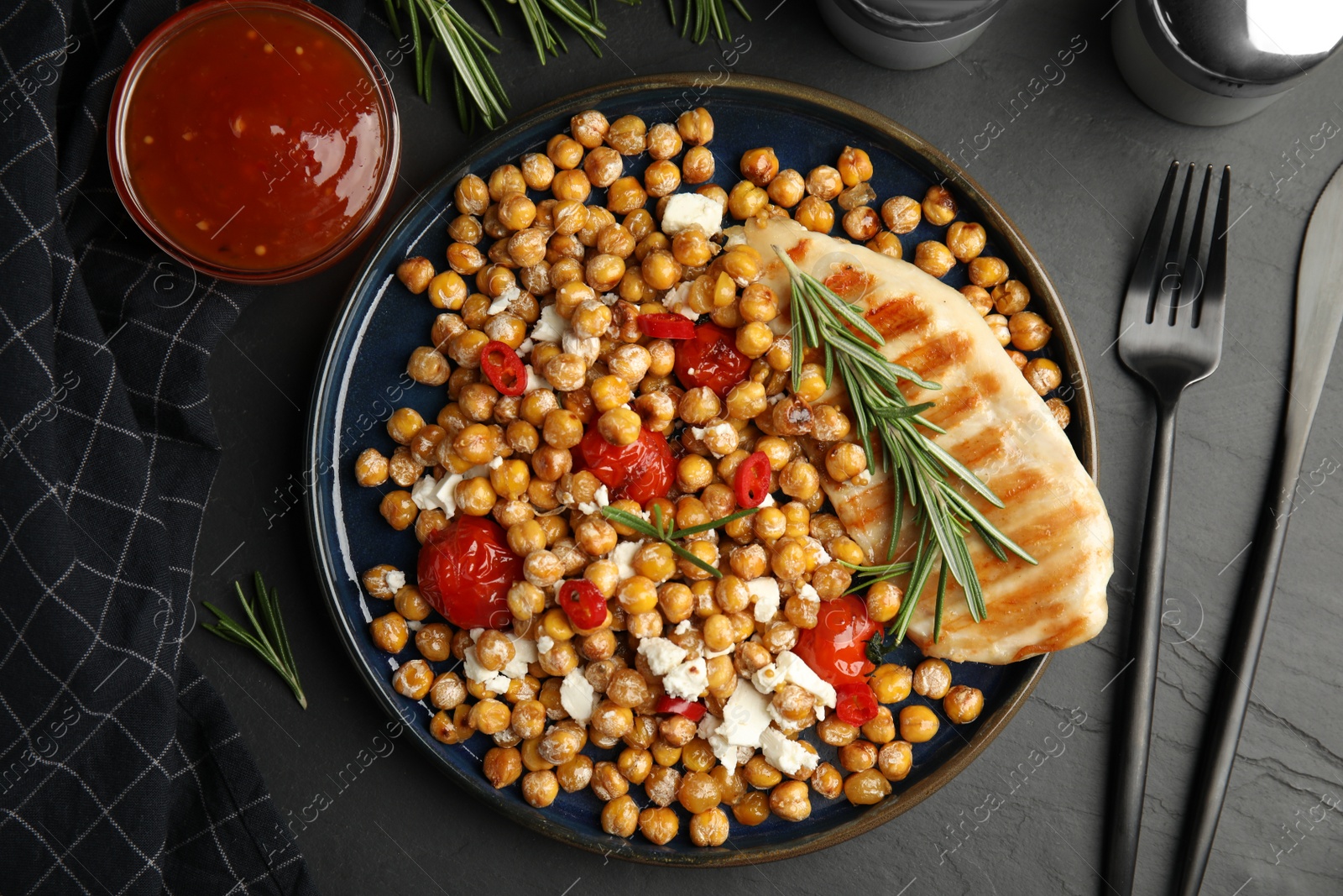 Photo of Delicious fresh chickpea salad served on black table, flat lay