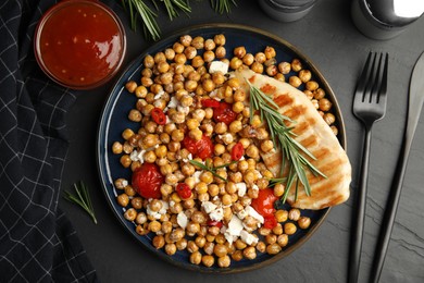 Photo of Delicious fresh chickpea salad served on black table, flat lay