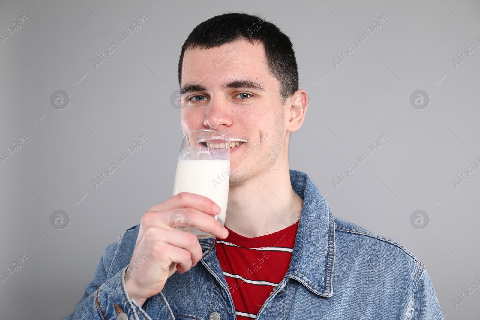 Photo of Milk mustache left after dairy product. Man drinking milk on gray background