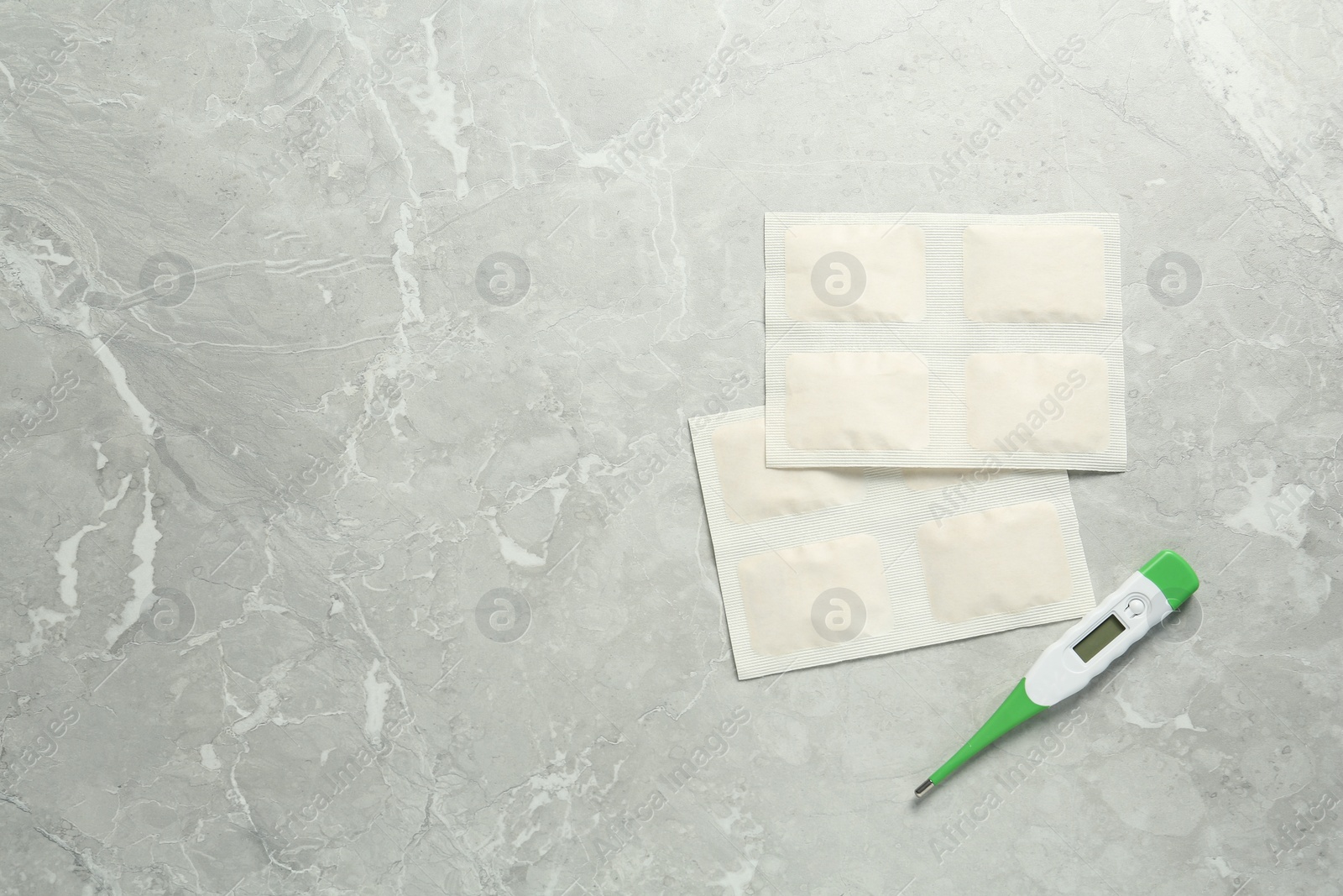 Photo of Mustard plasters and thermometer on light grey marble table, flat lay. Space for text