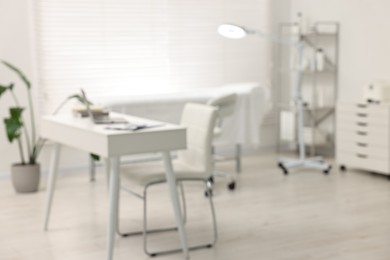 Photo of Blurred view of dermatologist's office with examination table