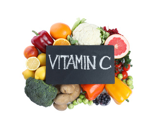 Photo of Board with phrase VITAMIN C and fresh products on white background, top view