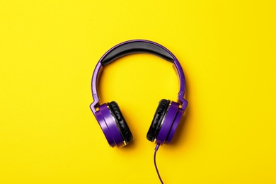 Photo of Stylish modern headphones on color background, top view