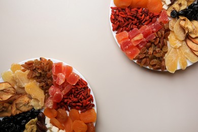 Photo of Plates with different dried fruits on white background, top view