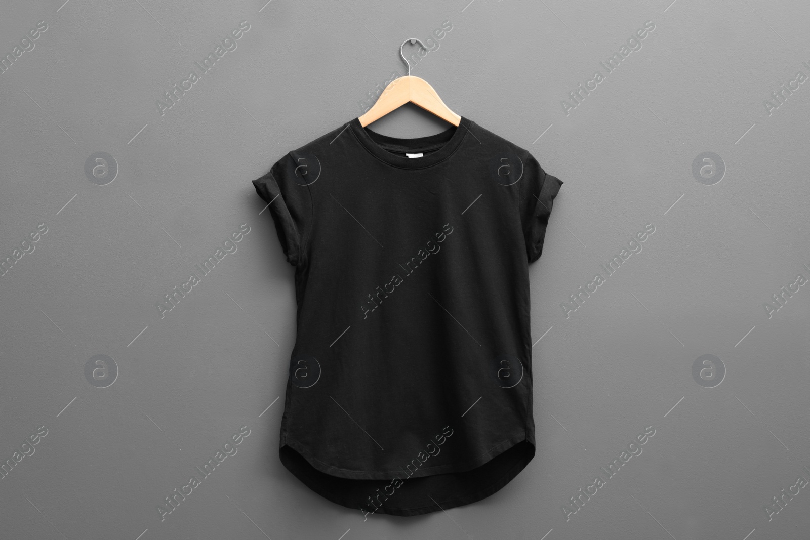 Photo of Hanger with blank t-shirt on grey background. Mockup for design