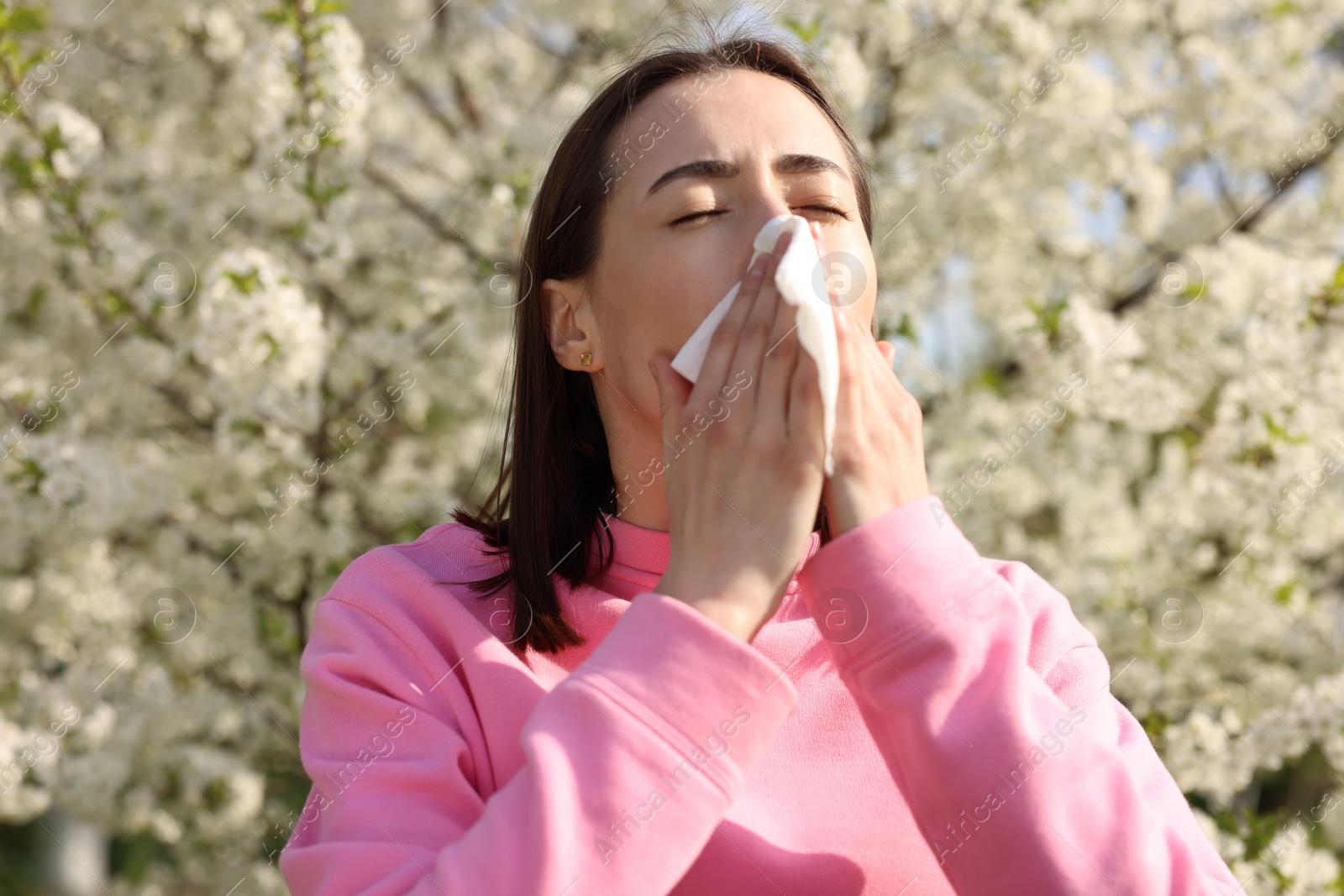 Photo of Woman with napkin suffering from seasonal allergy on spring day