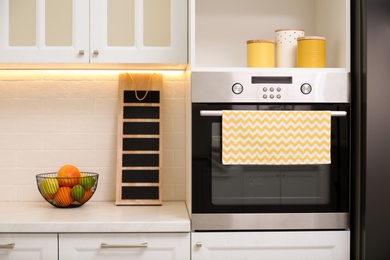 Photo of Clean towel on stove door in kitchen