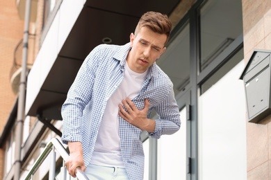 Photo of Young man having chest pain outdoors. Heart attack