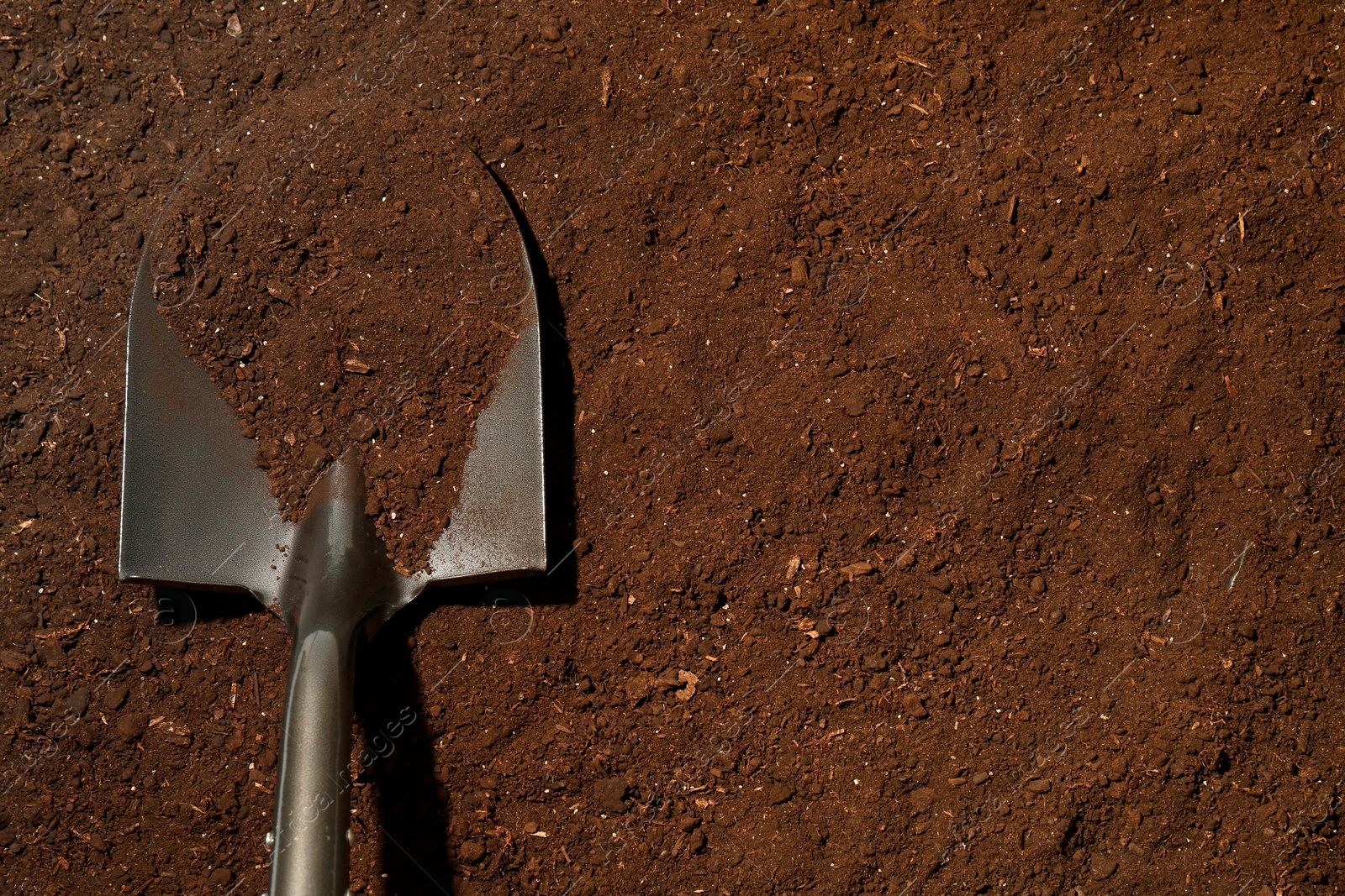 Metal shovel on fertile soil, top view and space for text. Gardening tool Photo of Metal shovel on fertile soil, top view and space for text. Gardening tool