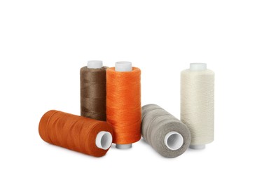 Many different colorful sewing threads on white background