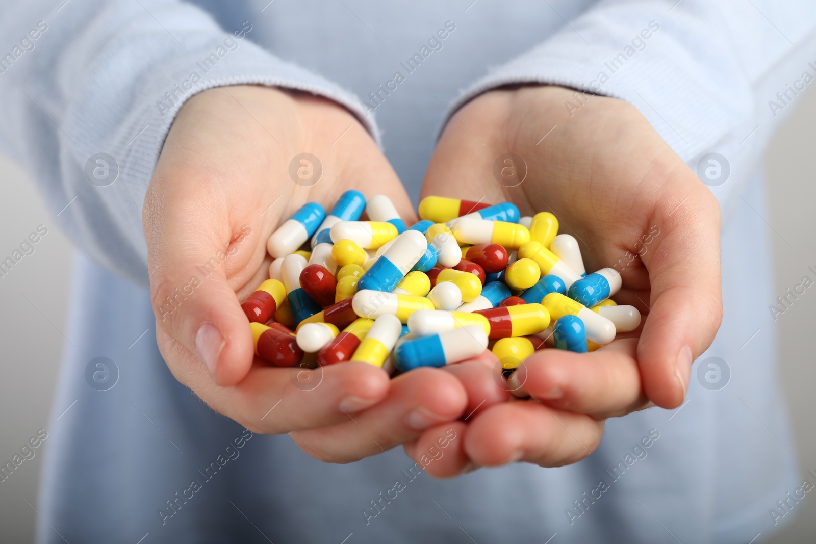 Photo of Woman holding many antibiotic pills, closeup. Medicinal treatment