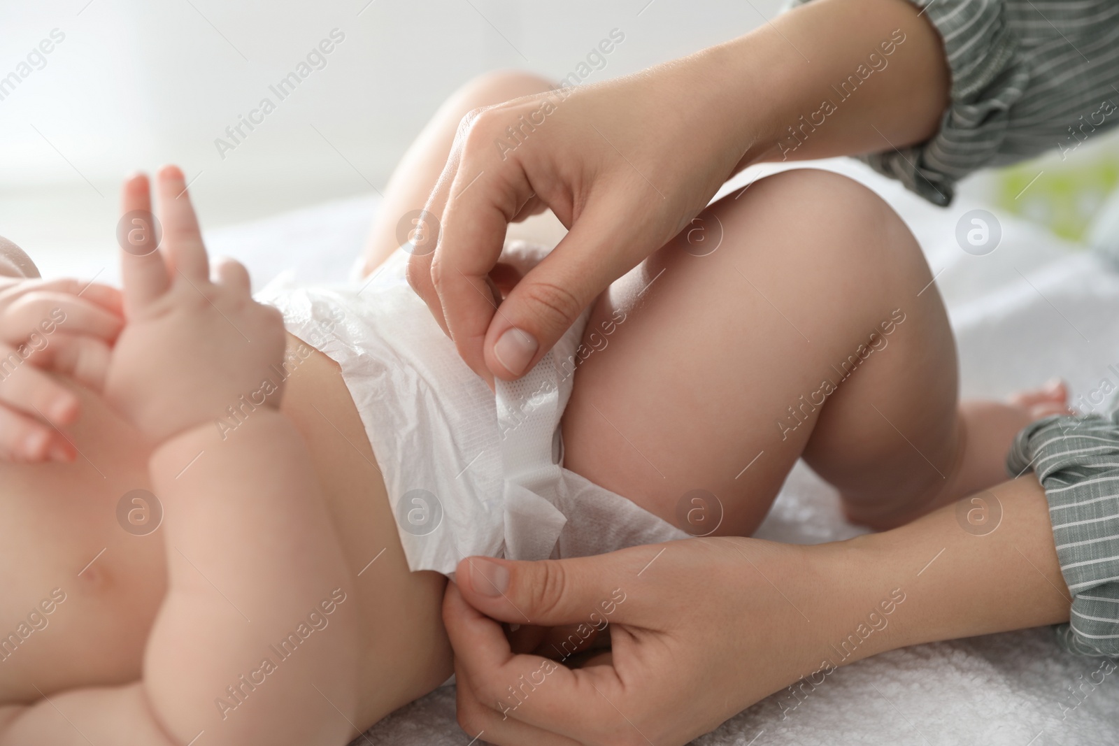 Photo of Mother changing her baby's diaper on table, closeup