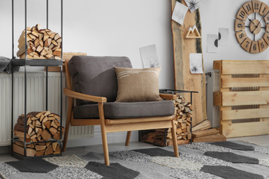 Photo of Stylish room interior with firewood as decorative element