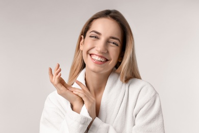 Photo of Beautiful young woman with silky skin on light background