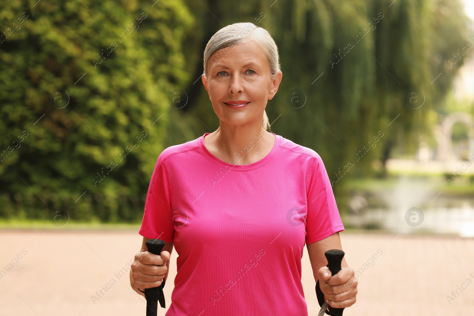 Photo of Senior woman with Nordic walking poles outdoors