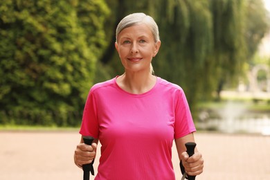 Senior woman with Nordic walking poles outdoors