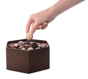 Woman taking chocolate candy out from box isolated on white, closeup