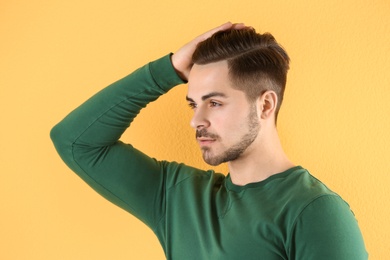 Portrait of young man with beautiful hair on color background