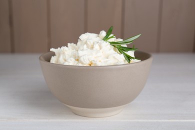 Delicious tofu cream cheese with rosemary in bowl on white wooden table