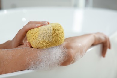 Photo of Woman with sponge taking bubble bath, closeup