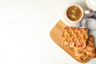 Photo of Fresh tasty pastries and coffee on white wooden table, flat lay. Space for text