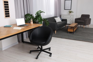 Photo of Stylish room interior with comfortable office chair, desk and houseplant