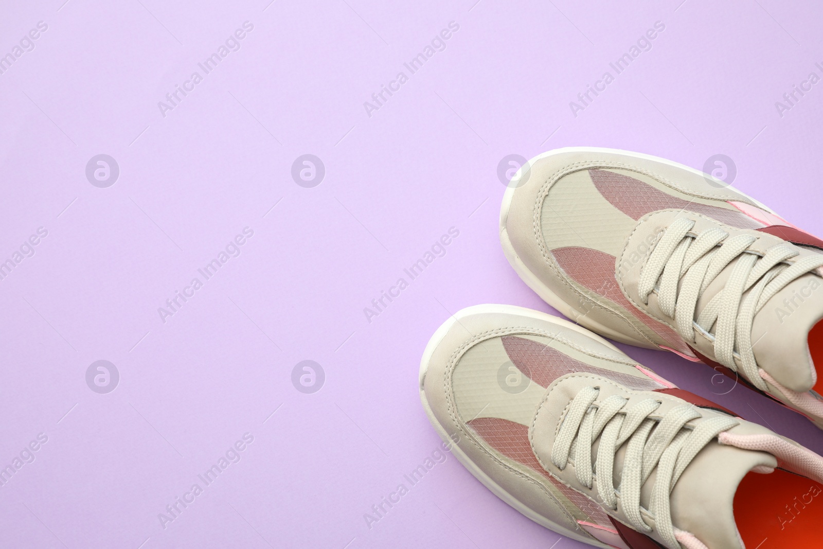 Photo of Pair of stylish shoes on lilac background, top view. Space for text