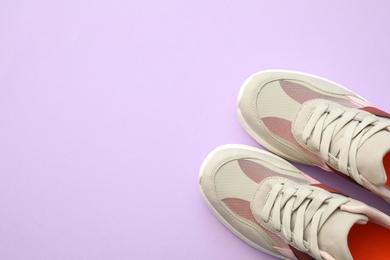 Photo of Pair of stylish shoes on lilac background, top view. Space for text