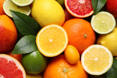 Photo of Different ripe citrus fruits as background, closeup