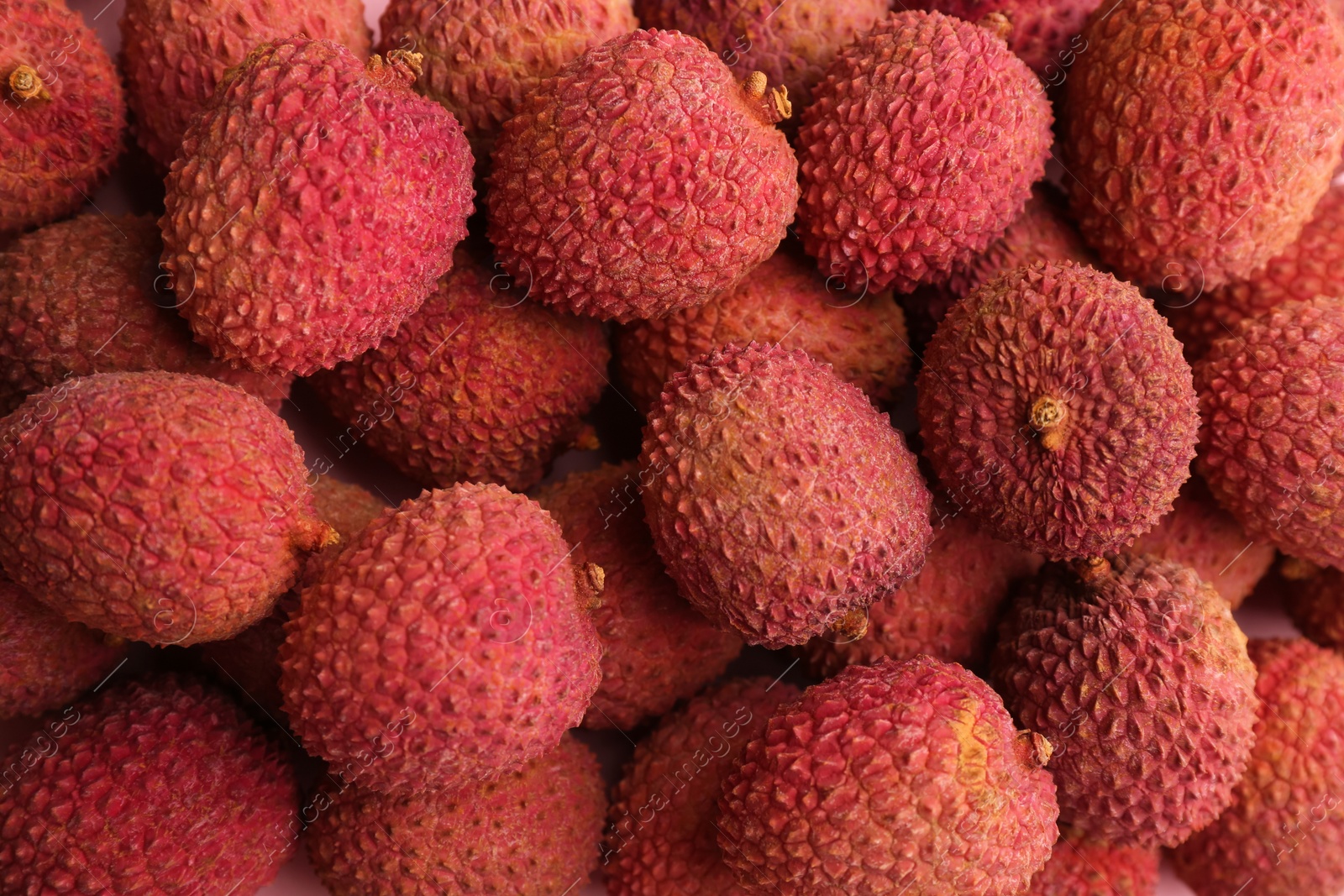 Photo of Pile of fresh ripe lychees as background, top view