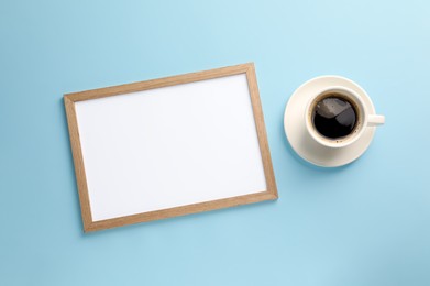 Photo of Blank white board with cup of coffee on turquoise background, flat lay. Space for text