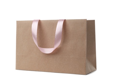 Paper shopping bag with ribbon handles on white background. Mockup for design