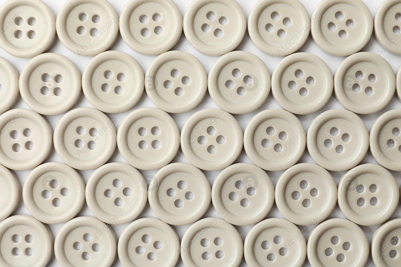 Photo of Many grey sewing buttons on white background, closeup