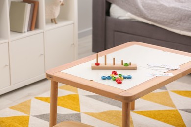 Stacking and counting game on table indoors, space for text. Educational toy for motor skills development