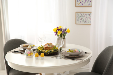 Festive Easter table setting with beautiful flowers and eggs indoors