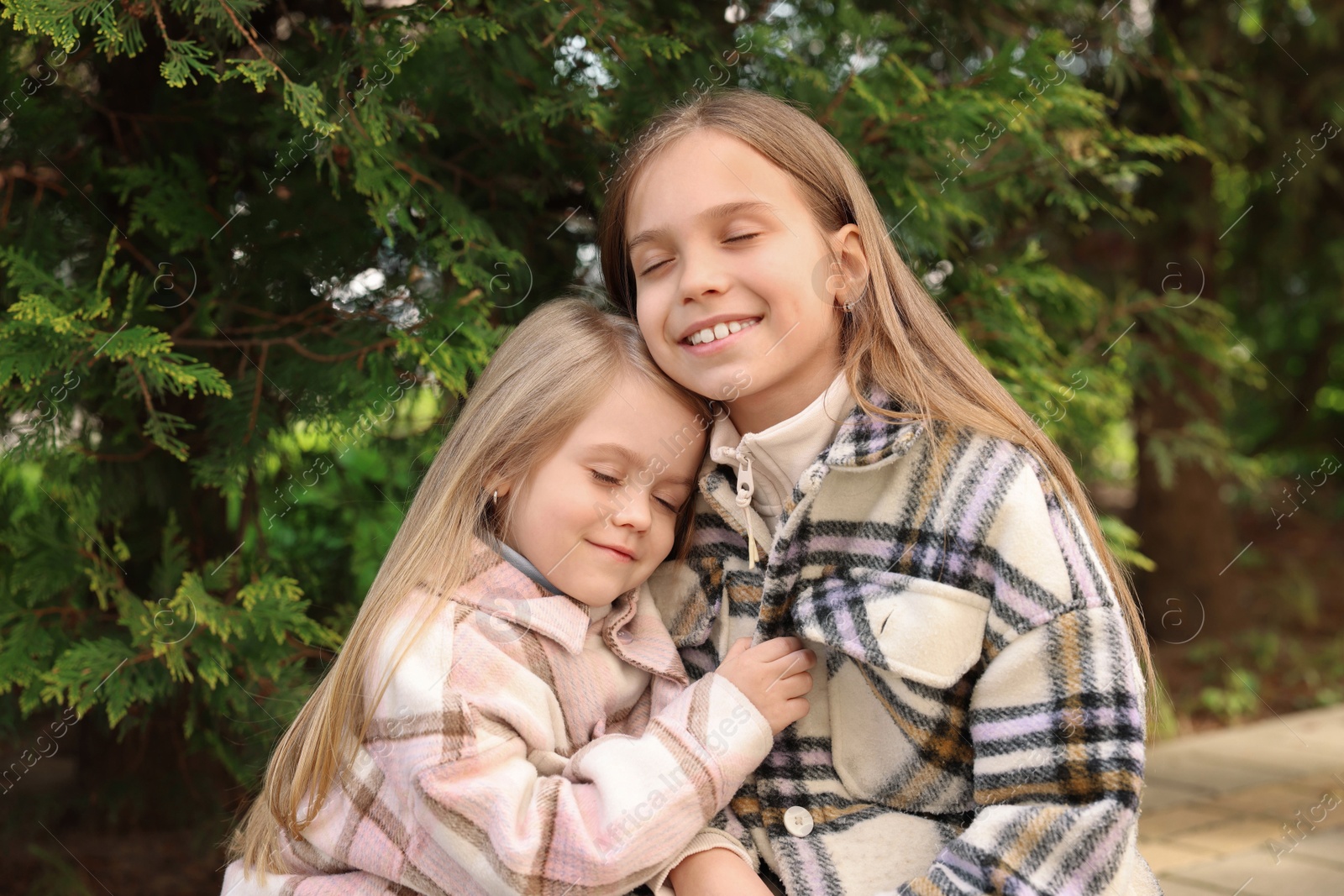 Photo of Cute little sisters spending time together outdoors