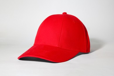 Photo of Stylish red baseball cap on white background