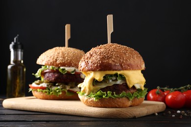 Vegetarian burgers with delicious patties on black wooden table